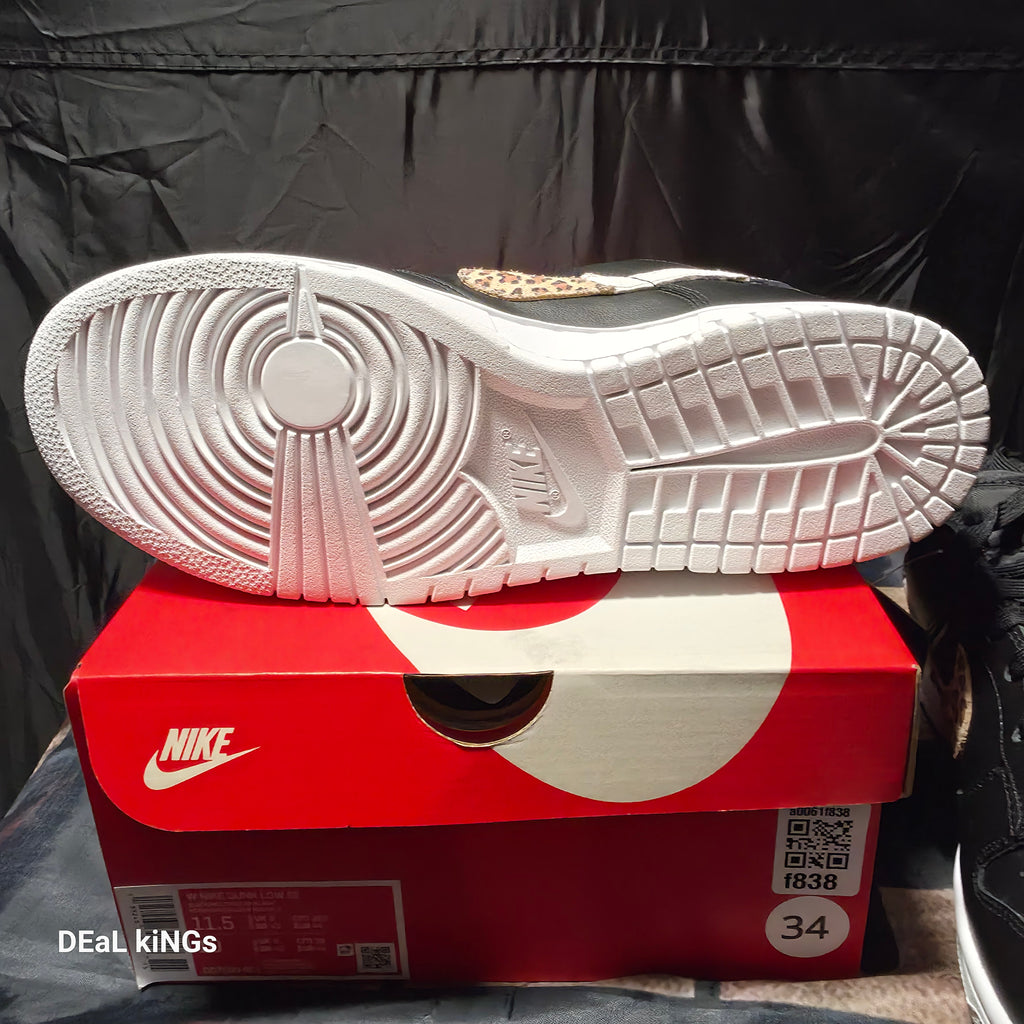 Nike Women's Dunk Low SE Primal sneakers feature a black leather upper with a distinctive animal print Swoosh.