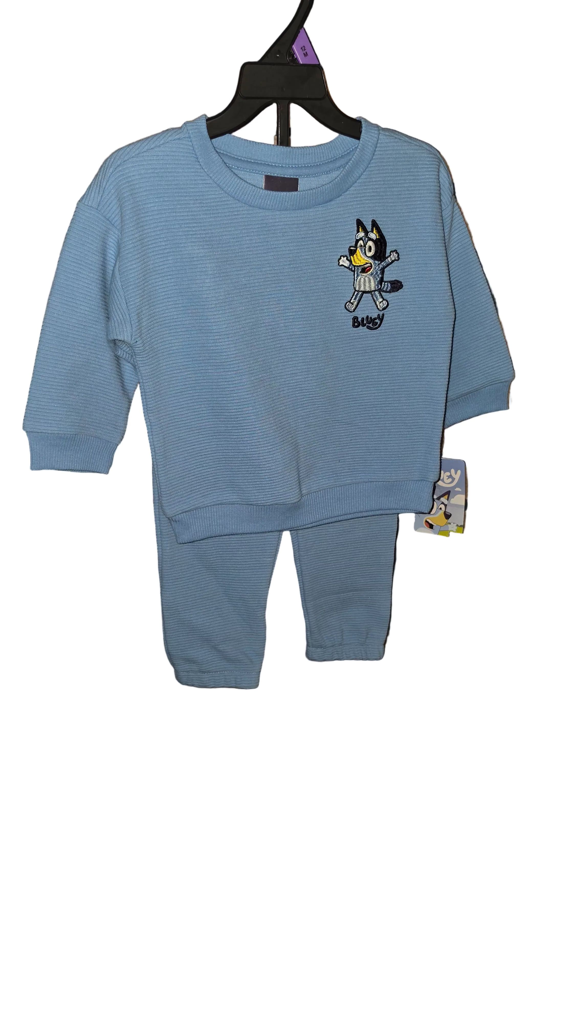 Blue baby outfit with cartoon character on a black background