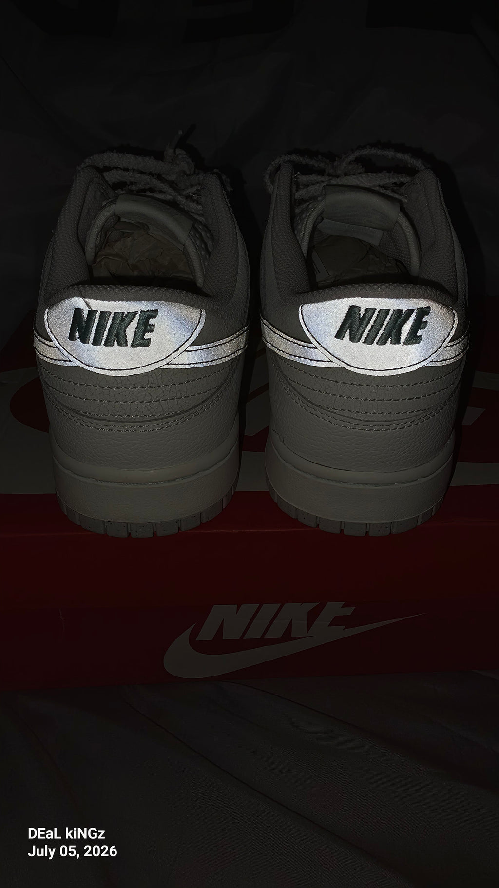 Nike Dunk Low SE "Winter Storm" sneakers, featuring a white textured upper and metallic silver reflective swooshes.