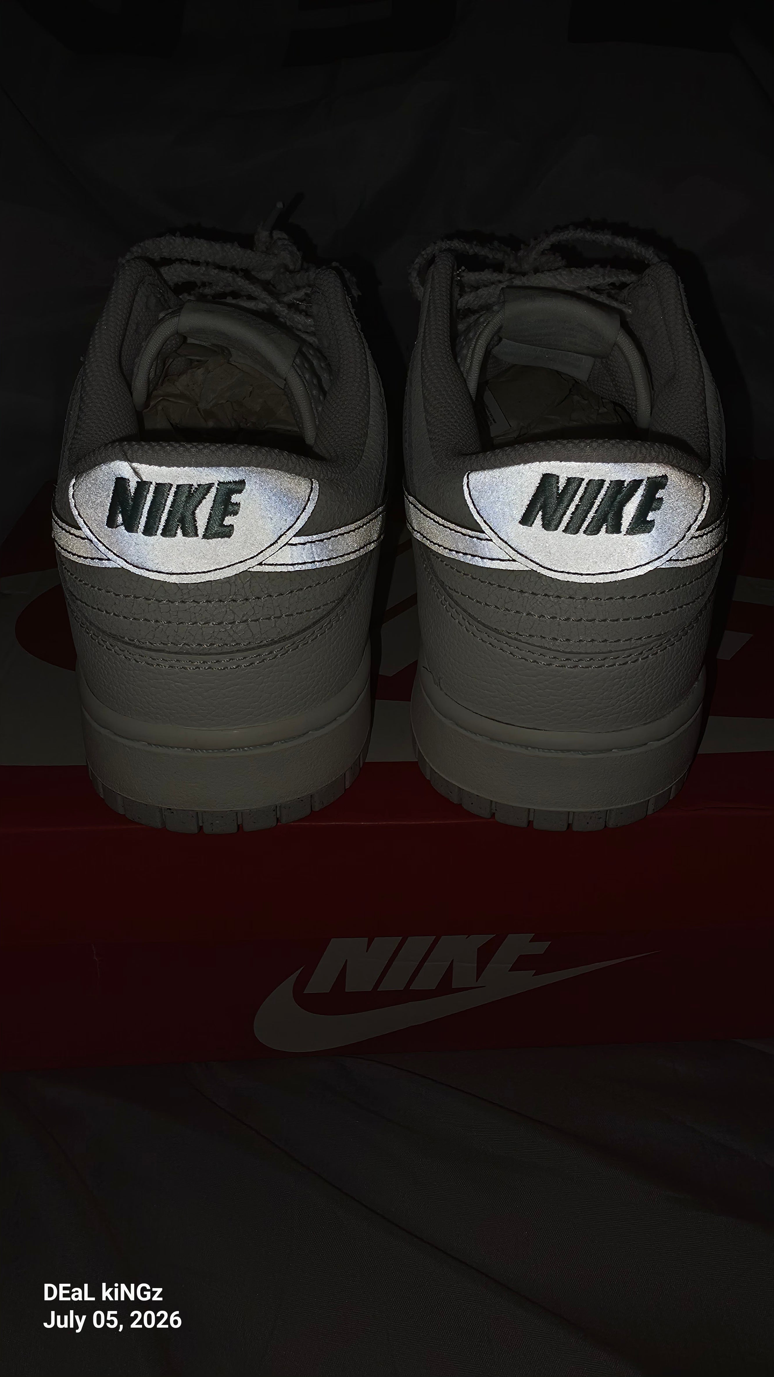Nike Dunk Low SE "Winter Storm" sneakers, featuring a white textured upper and metallic silver reflective swooshes.