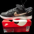 Nike Women's Dunk Low SE Primal sneakers feature a black leather upper with a distinctive animal print Swoosh.
