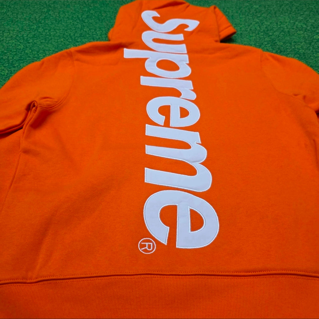 Supreme Satin Appliqué Hooded Sweatshirt in Bright Orange, featuring a large white satin logo running vertically down the back.