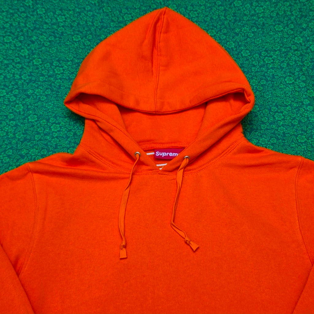 Supreme Satin Appliqué Hooded Sweatshirt in Bright Orange, featuring a large white satin logo running vertically down the back.