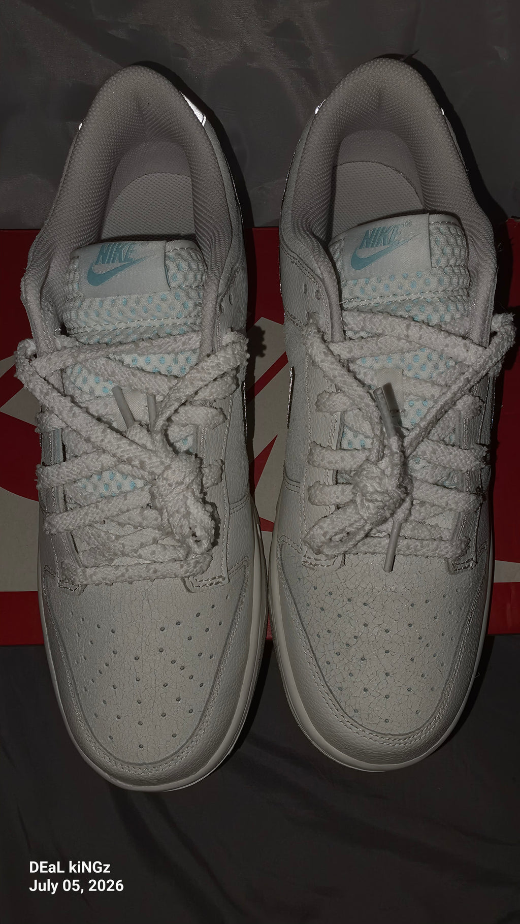 Nike Dunk Low SE "Winter Storm" sneakers, featuring a white textured upper and metallic silver reflective swooshes.