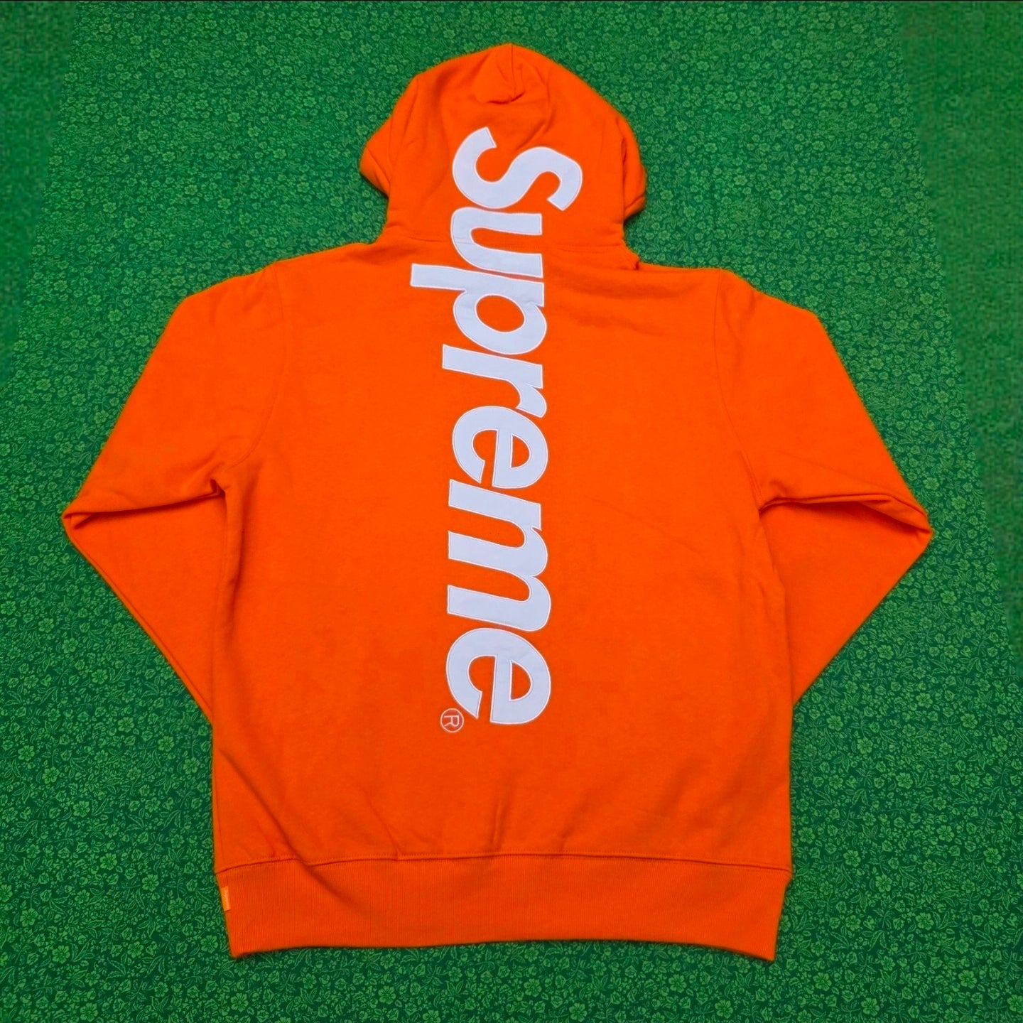 Supreme Satin Appliqué Hooded Sweatshirt in Bright Orange, featuring a large white satin logo running vertically down the back.